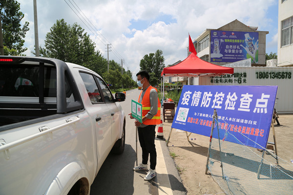 6.在王沟生产区卡口，党员志愿者王鹏不顾汗水湿透衣衫，每天坚持站岗执勤_副本_副本.jpg