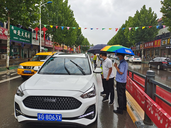 11.机关党员顾金同，雨中与民警一起，对过关可疑车辆进行进一步询问检查_副本_副本.jpg